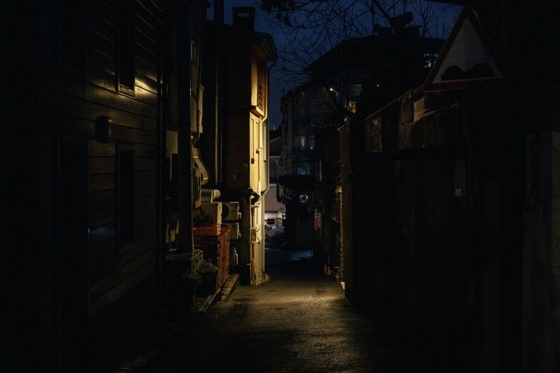 En mörk gränd mellan hus med en ensam lykta