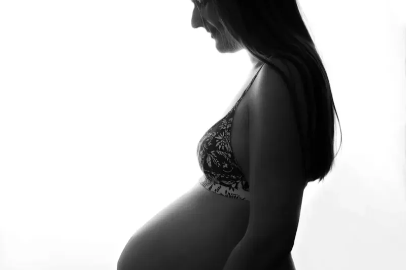 Siluett av en gravid kvinna mot ett mjukt motljus