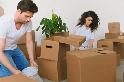 Två personer som packar kartonger när de flyttar