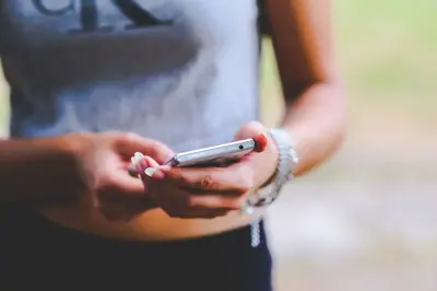 Två händer som håller i en mobiltelefon