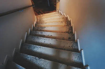 En trappa som leder uppåt mot ett ljust fönster