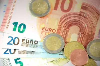 Sedlar och mynt utspridda i en hög