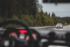 En mörk bil på en öde, öppen väg