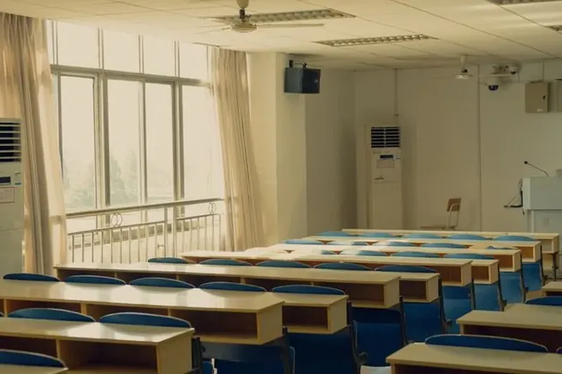 Rader av bänkar och stolar i ett tomt klassrum